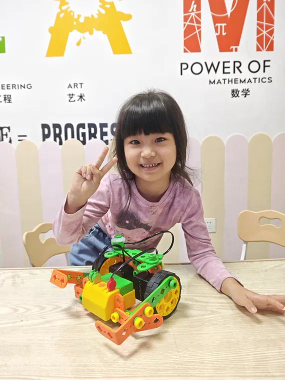 学员展示绿色和橙色的轮式机器人作品