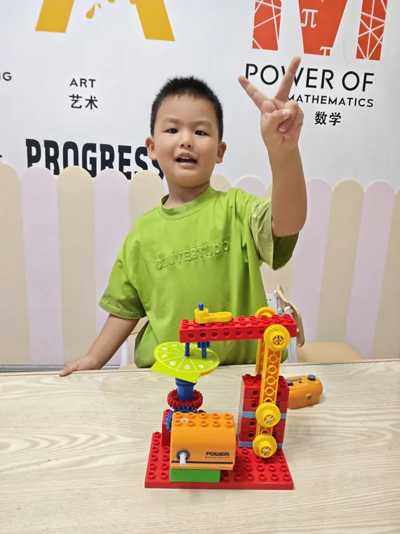学员展示带有齿轮和转盘的机器人作品