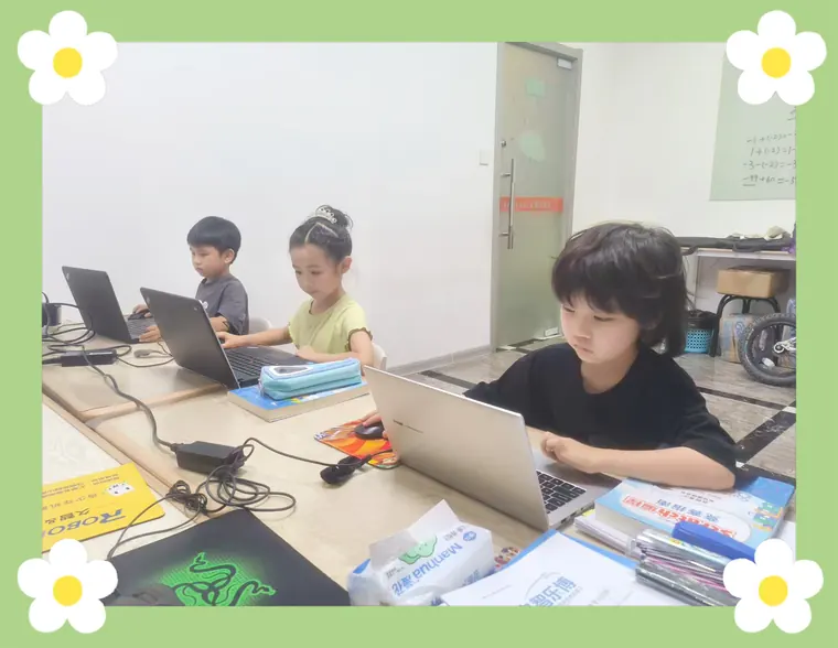三名学员在教室使用笔记本电脑学习